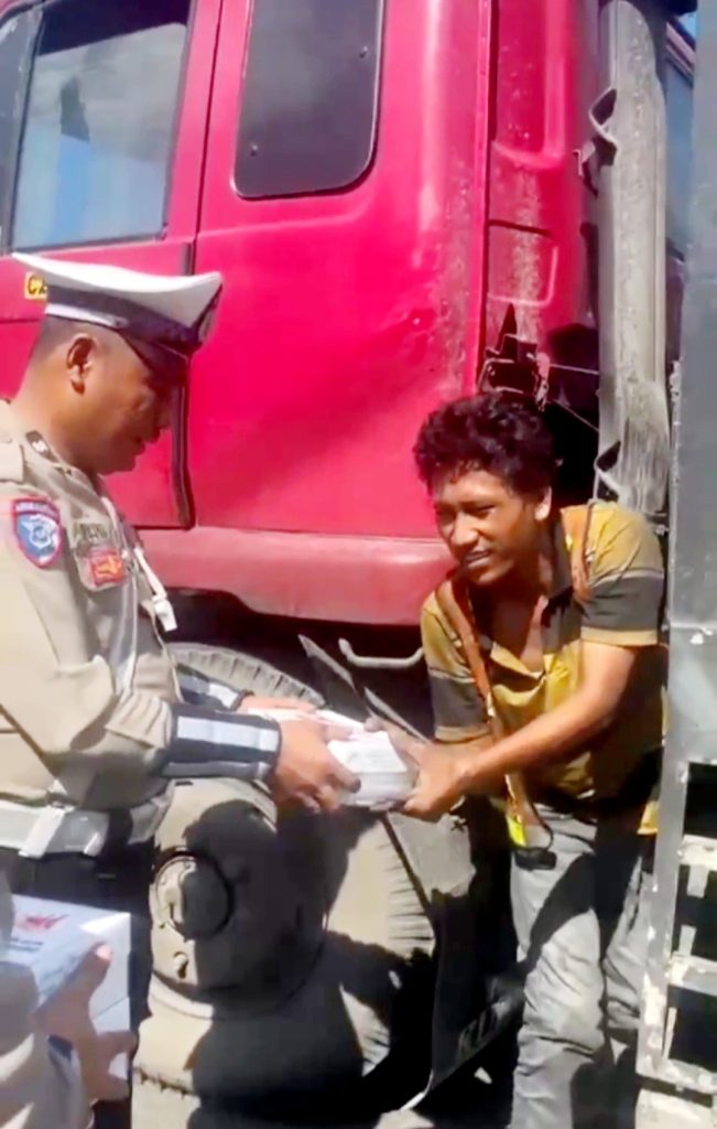 Foto:Personel SATLANTAS Sedang Membagikan Nasi Buka Puasa Kepada Sopir Truck