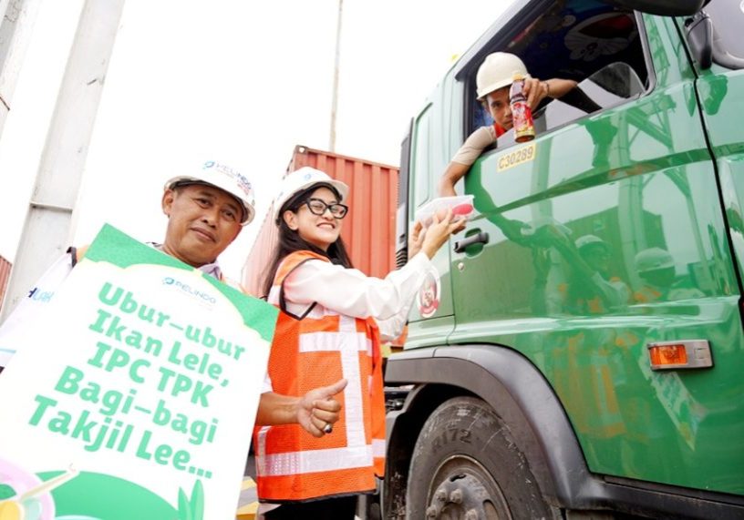 Karyawan IPC TPK sedang membagikan takjil kepada pengemudi Truck